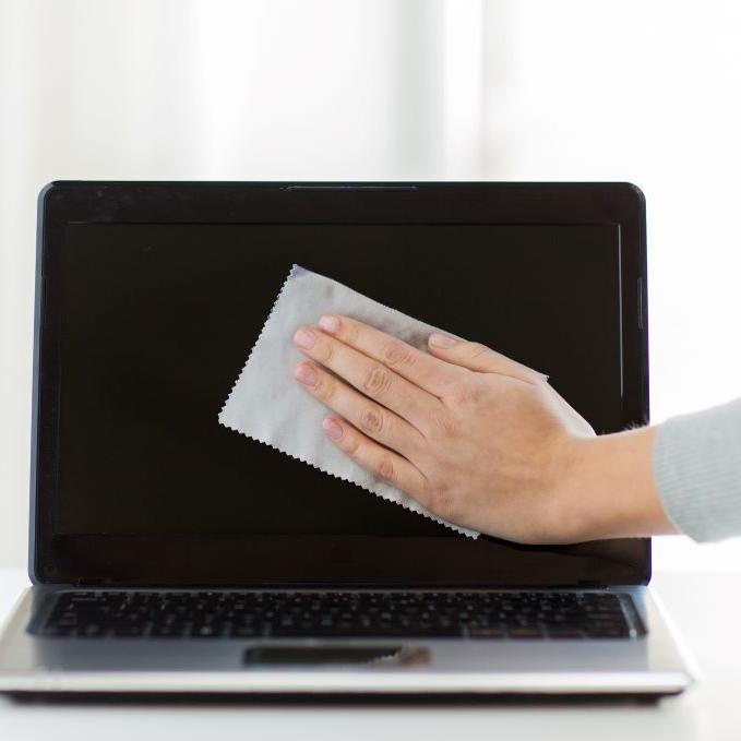 一名妇女正在清洁乐投letou下载的屏幕，以确保电脑得到适当的维护.